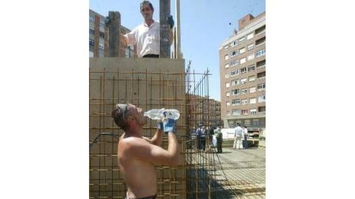 Uno de los empleados que construye la fuente de Pinilla refrescándose