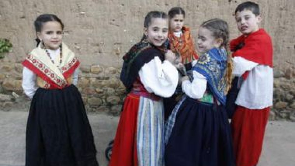 Varios niños vestidos con trajes tradicionales bromean durante el rodaje del documental