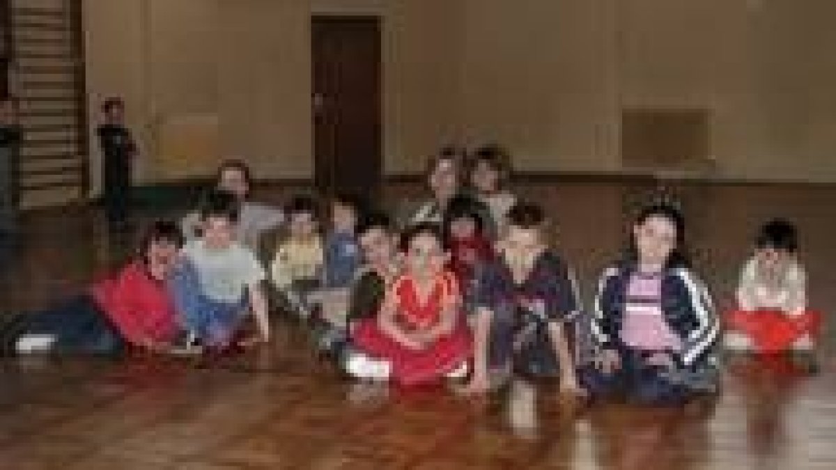 Los más pequeños posan en el gimnasio junto a la monitora Erika