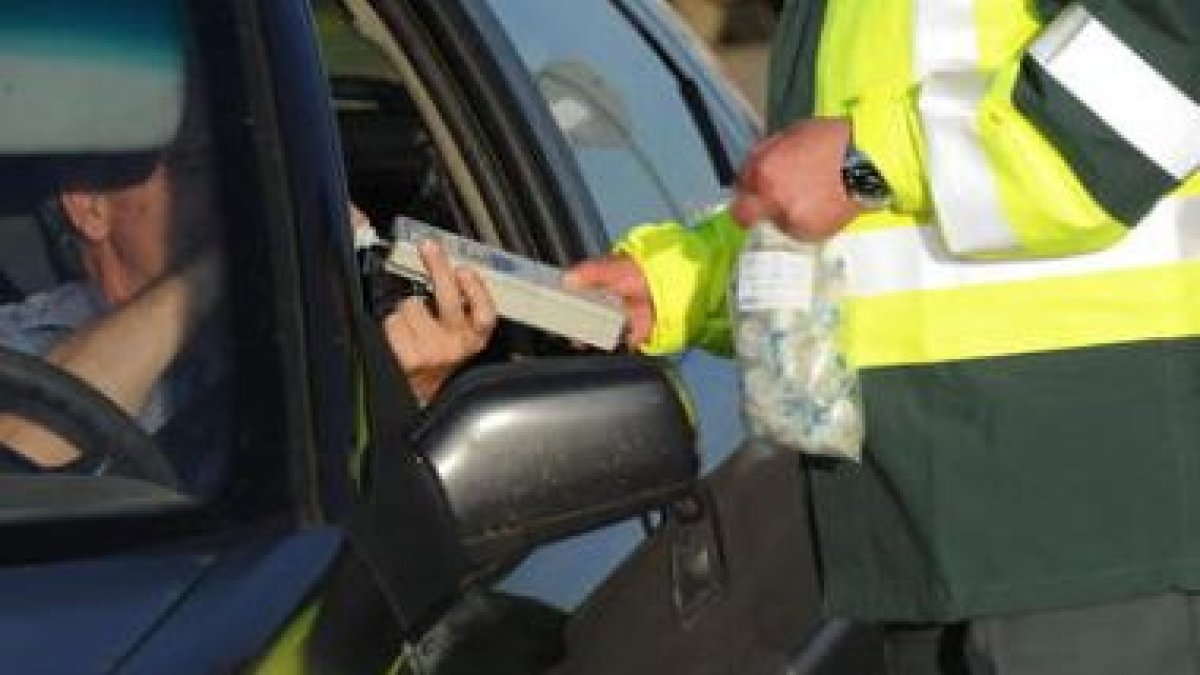 Un agente de la Guardia Civil realiza la prueba de alcoholemia a un conductor.