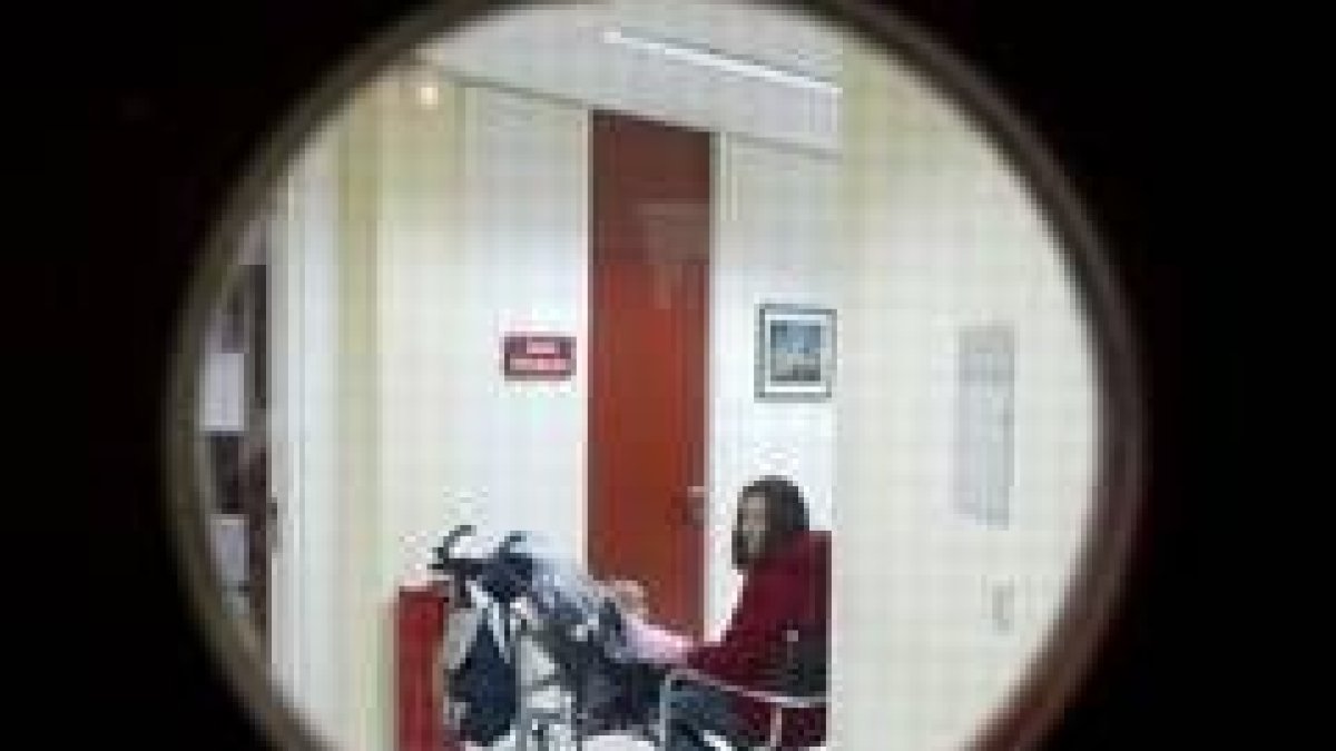 Una mujer búlgara, con su hija nacida en León, espera ante la oficina de inmigración de UGT