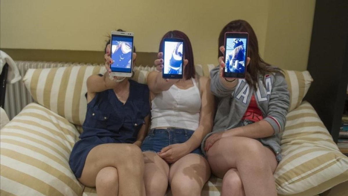 Laura (centro), junto a dos amigas, muestran una foto tomada por la aplicación Snapchat en sus móviles.