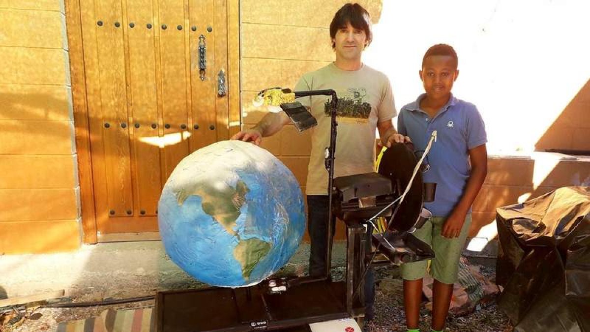 Óscar Cela y su hijo Henok, posando con el artilugio premiado que fotografía la tierra. DL