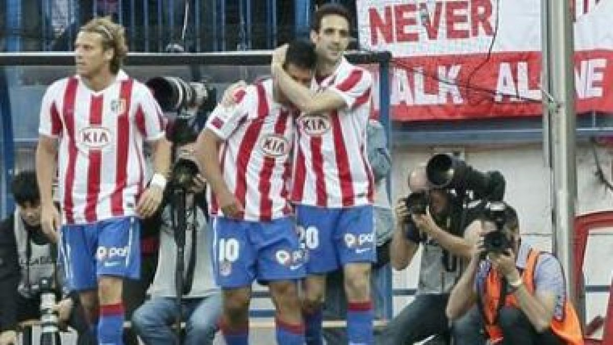 Agüero celebra su gol con Diego Forlán y Juanfran.