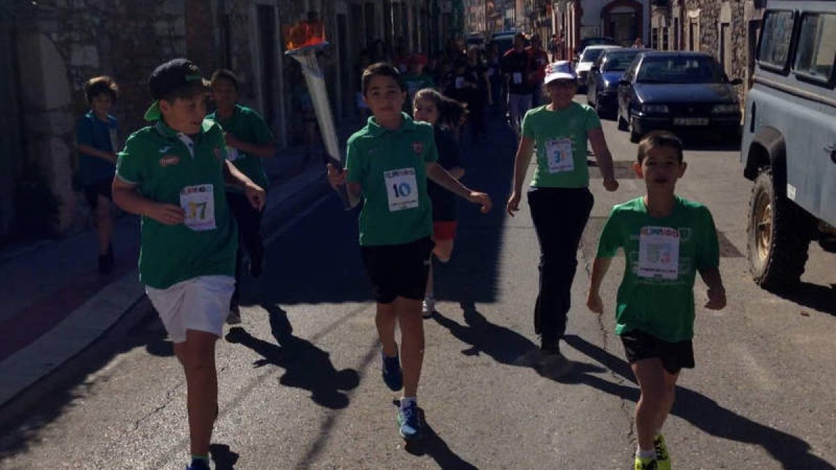 Los alumnos pasean la antorcha olímpica por las calles de La Pola de Gordón. DL