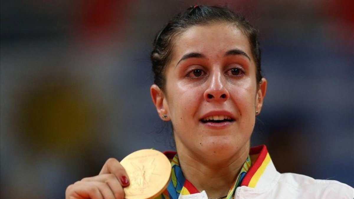 Carolina Marín llora en el podio con el oro olímpico colgado.