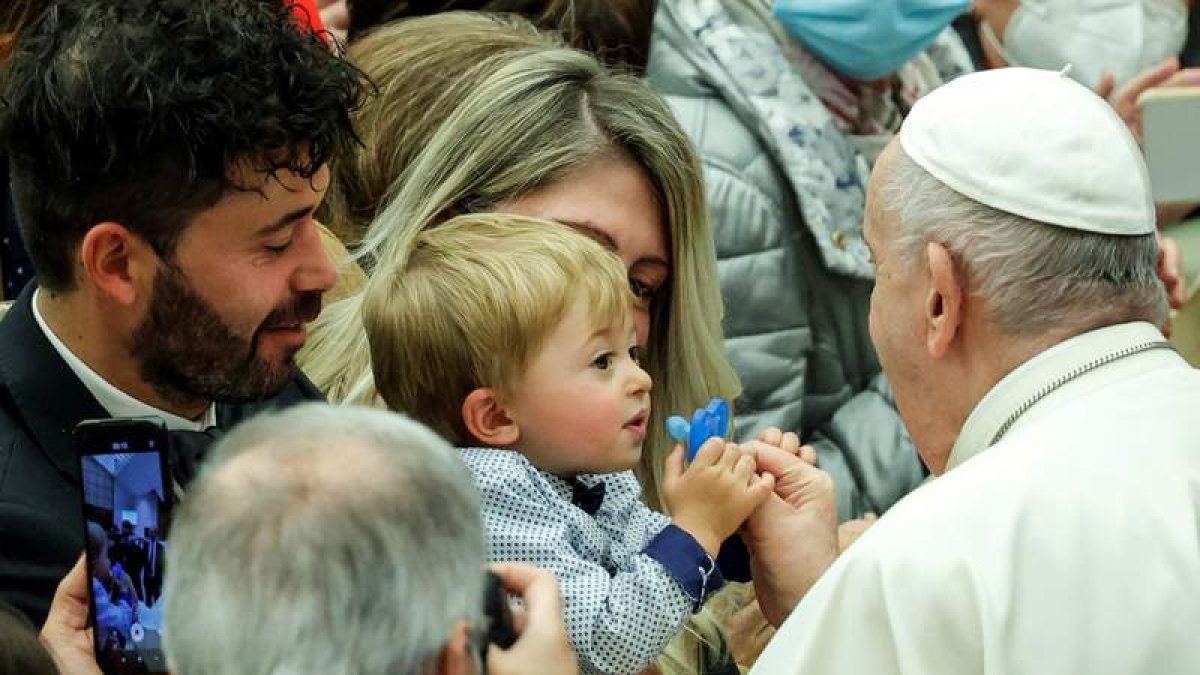 El papa le pone el chupete a un bebé, durante la celebración ayer de la audiencia semanal en el Vaticano. GIUSEPPE LAMI