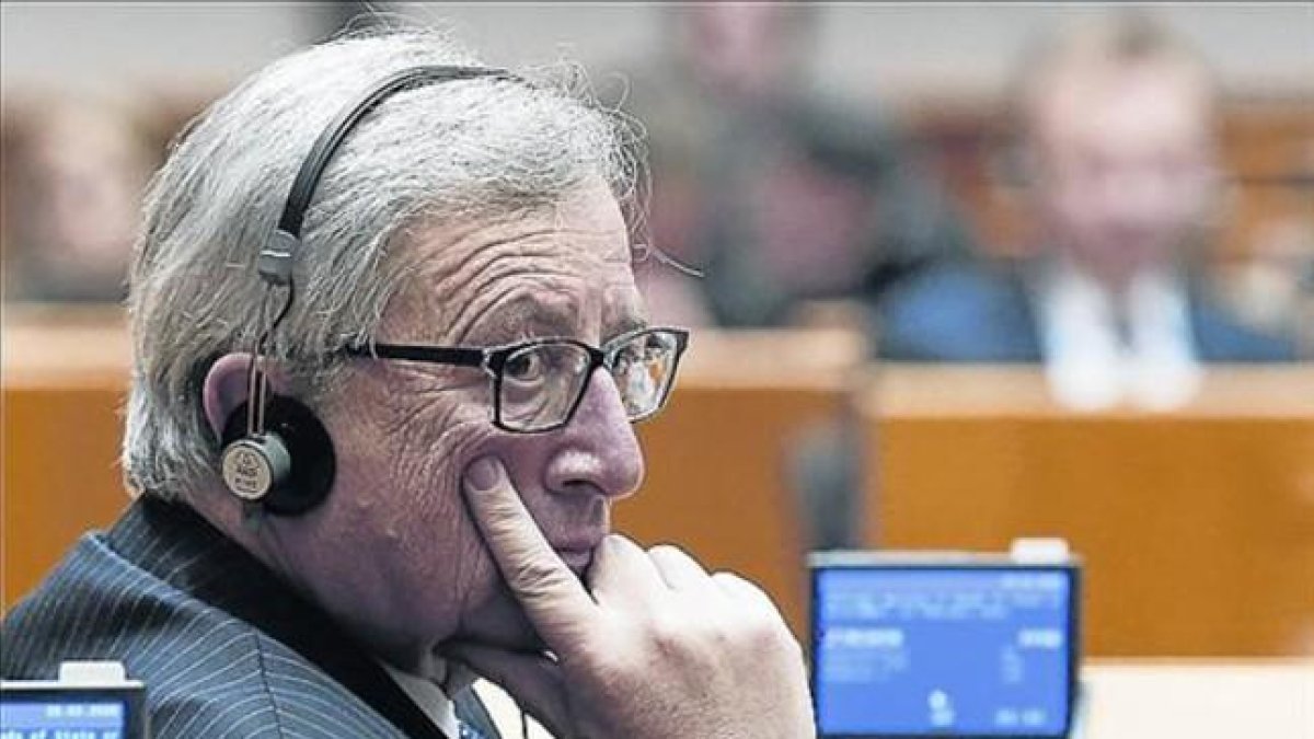 Jean-Claude Juncker, con unos auriculares de traducción en un pleno del Parlamento europeo.