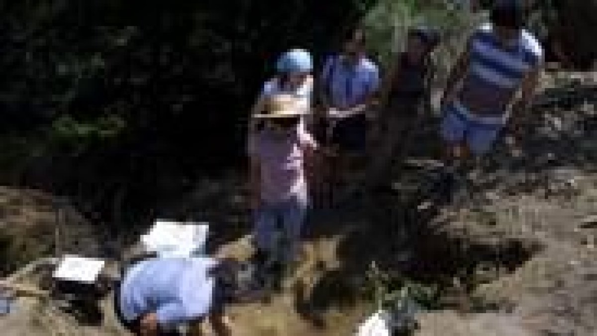 Una voluntaria de la asociación recupera restos de la fosa de Pardamaza