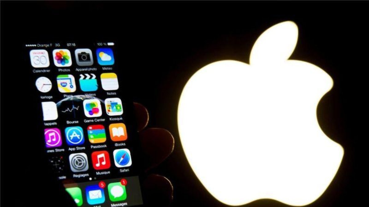 Un iPhone junto al logo de Apple.