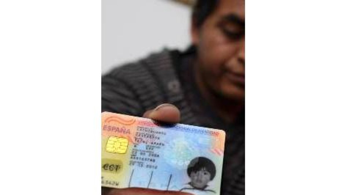 El padre del niño muestra el carné de identidad del pequeño, expedido en España