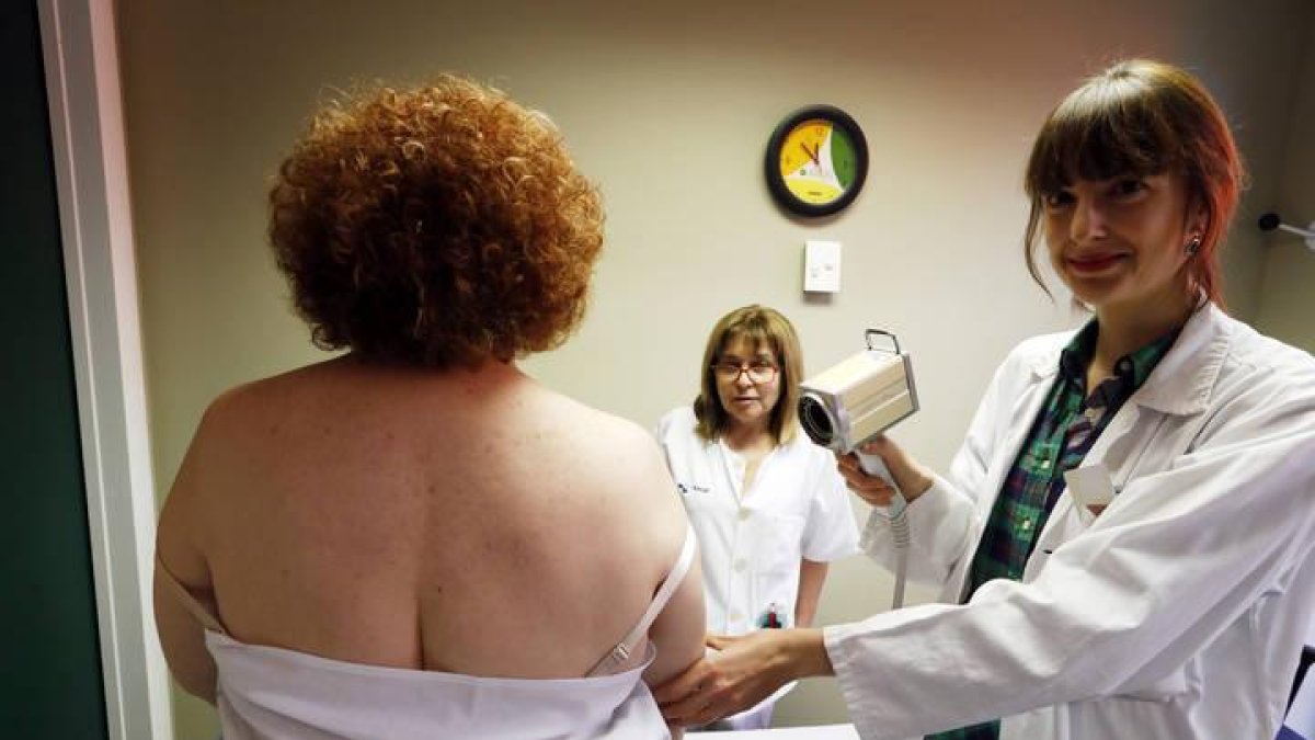 La doctora Elia Samaniego fotografía los lunares de una paciente para comprobar si alguno ha crecido o cambiado de color gracias al dermoscopio de mano.