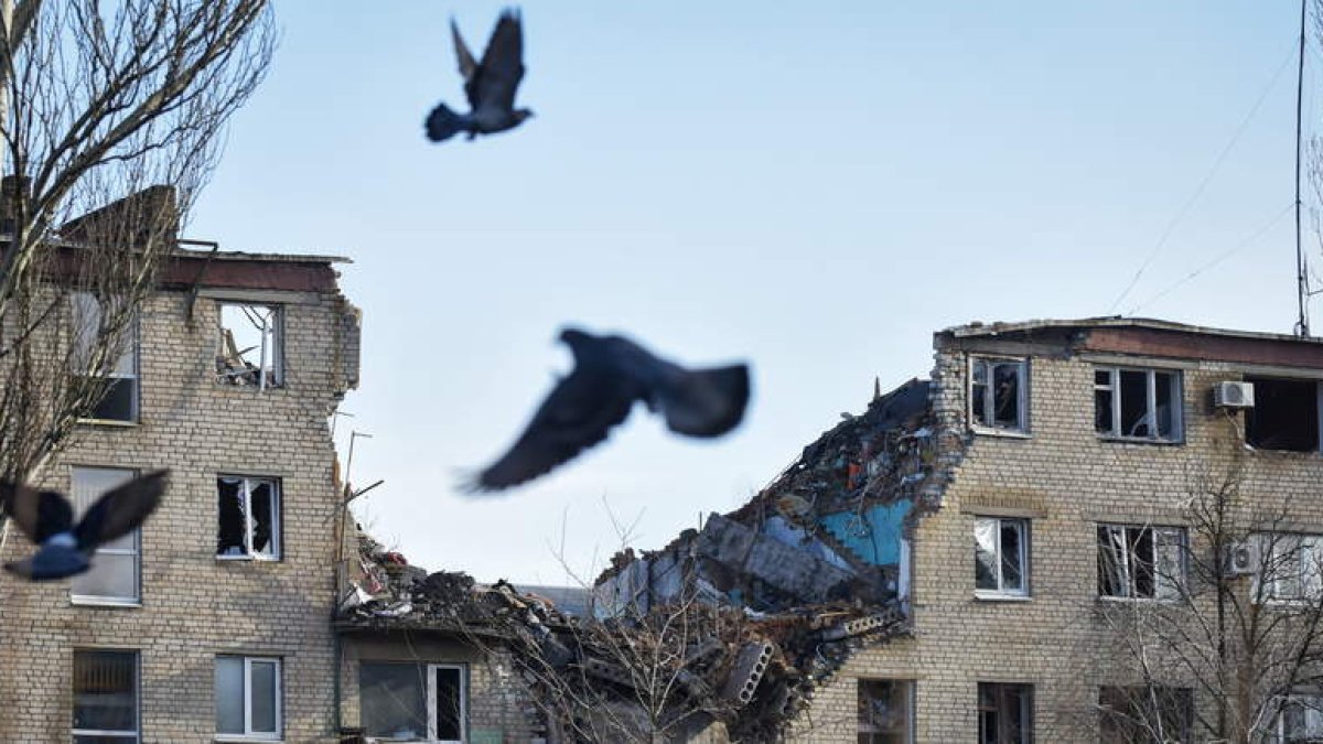 Unas palomas vuelan frente a los restos de un bloque de casas en la ciudad ucraniana de Bajmut. OLEG PETRASYUK