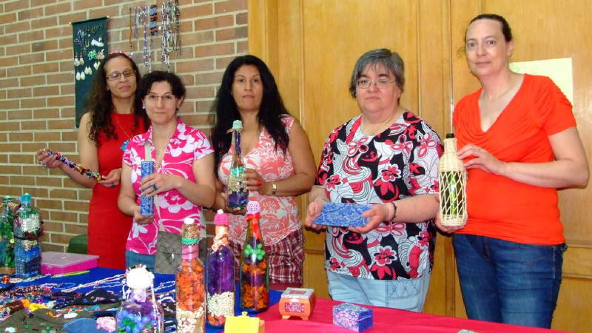 Cinco de las mujeres anticrisis posan durante la exposición de manualidades que organizaron.