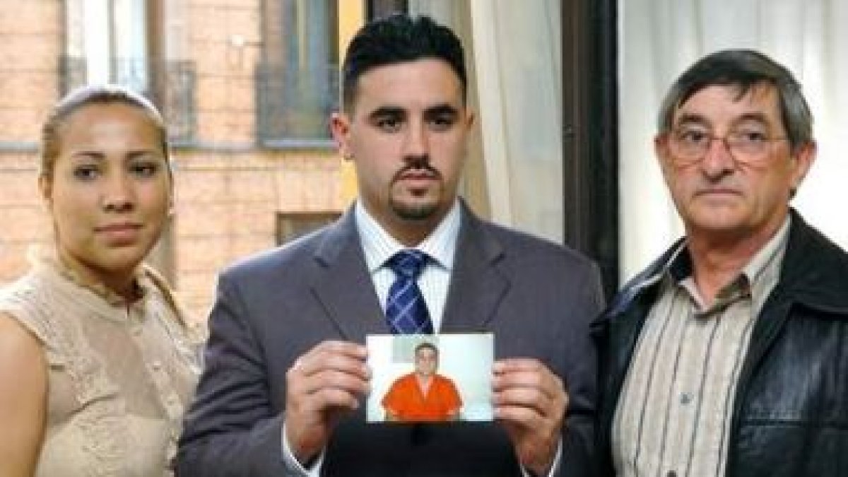 La esposa, el hermano y el padre de Pablo Ibar sujetan una foto del preso.