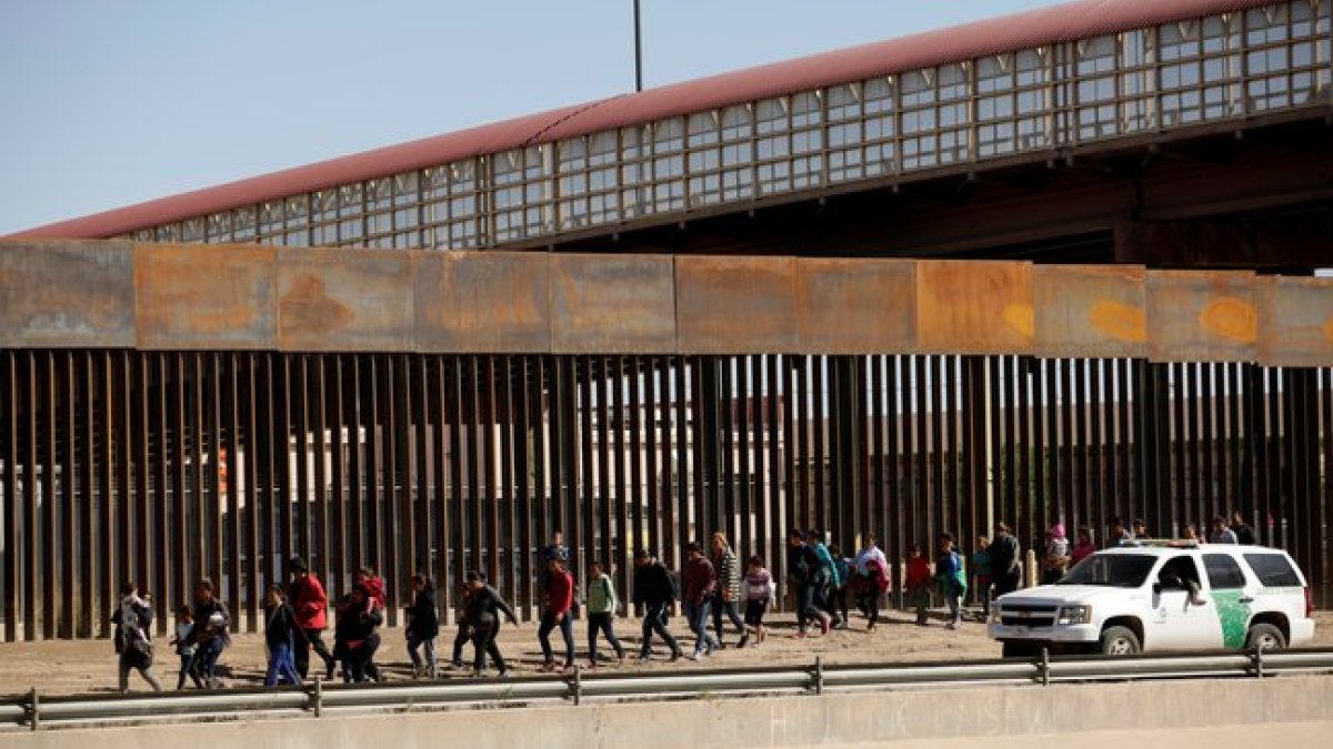 Oficiales migratorios de los Estados Unidos vigilan a los detenidos.
