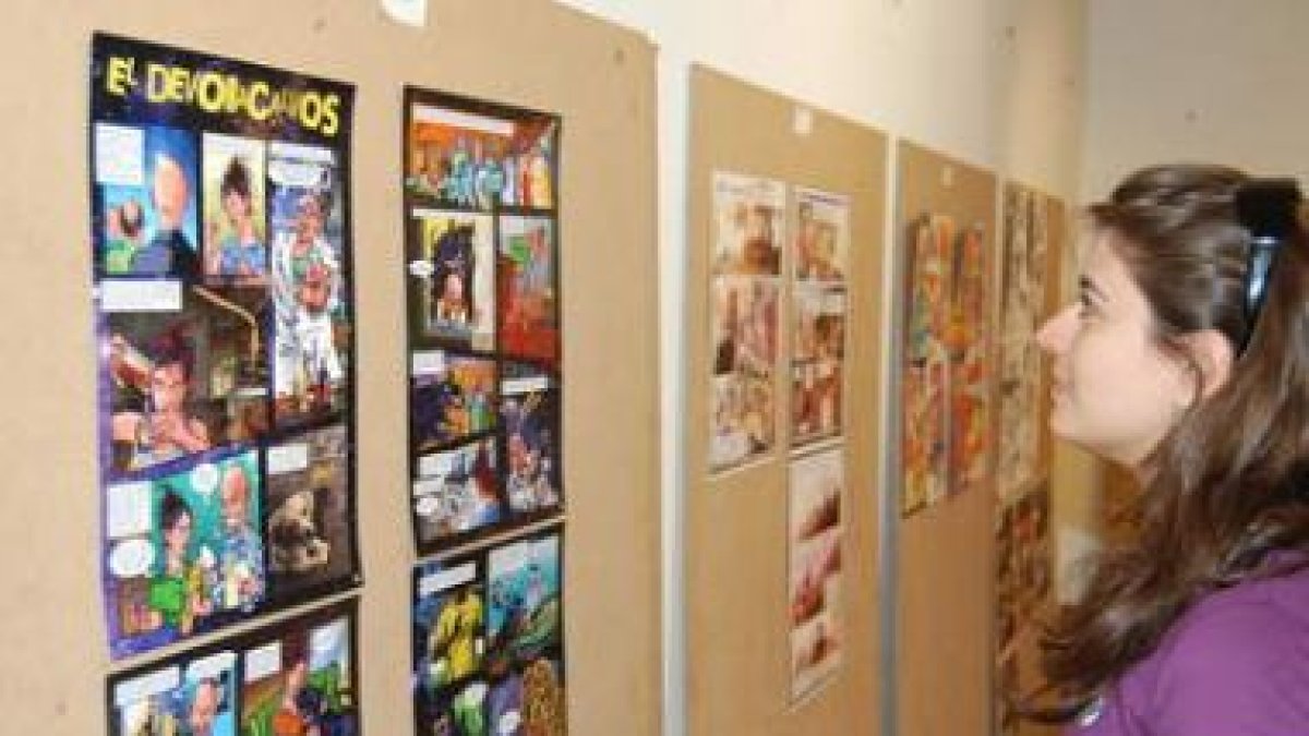 Una joven observa las ilustraciones de un cómic en la muestra.