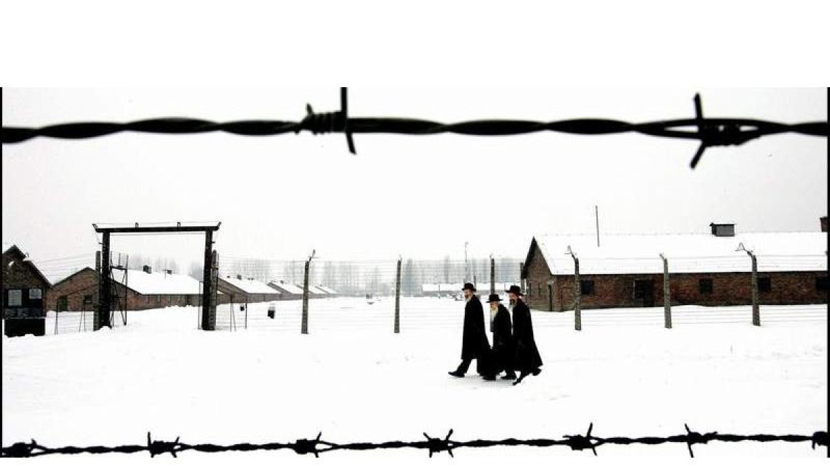 Tres judíos caminan por el campo de concentración de Auschwitz, donde se celebró solo una boda hace 70 años.