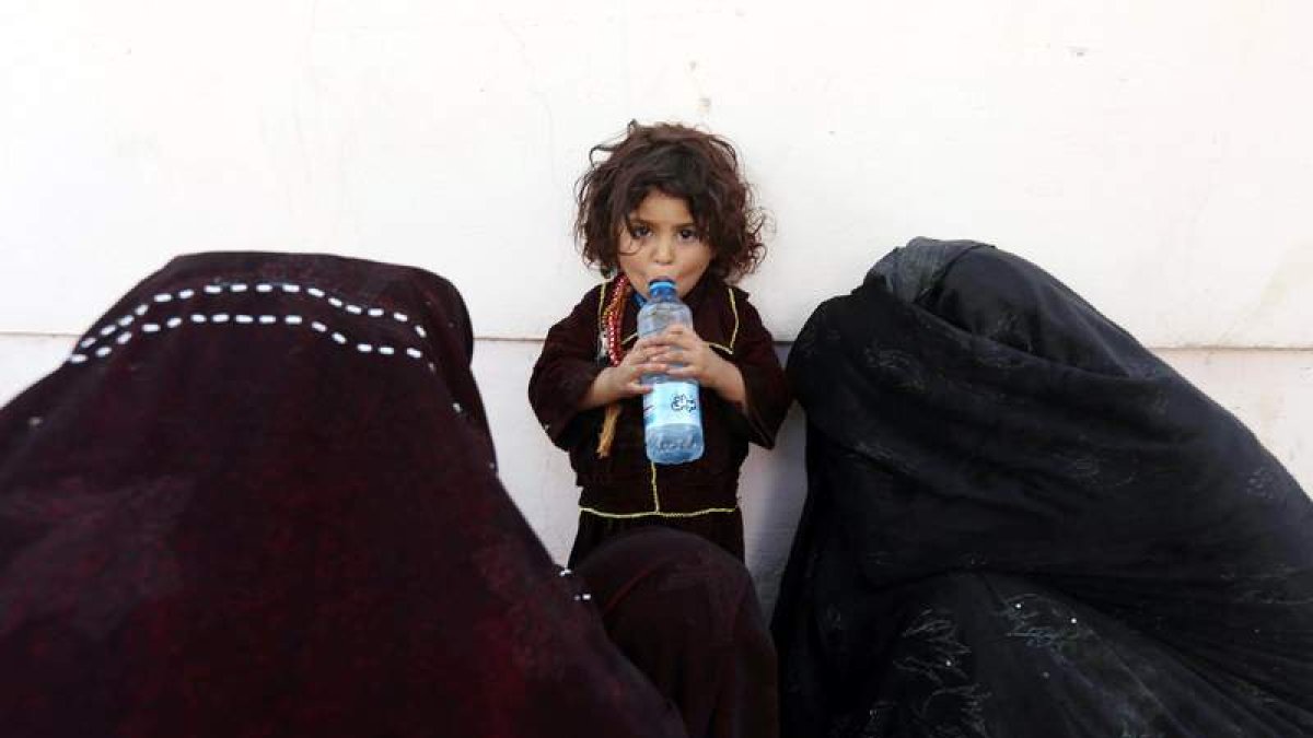 Una niña refugiada bebe agua en Herat, Afganistán, ayer. JALIL REZAYEE