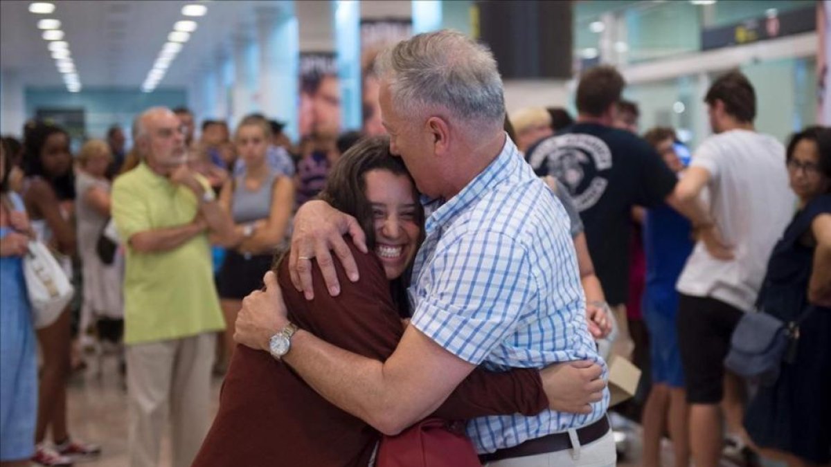 Un padre abraza a su hija en El Prat a su llegada de Estambul.