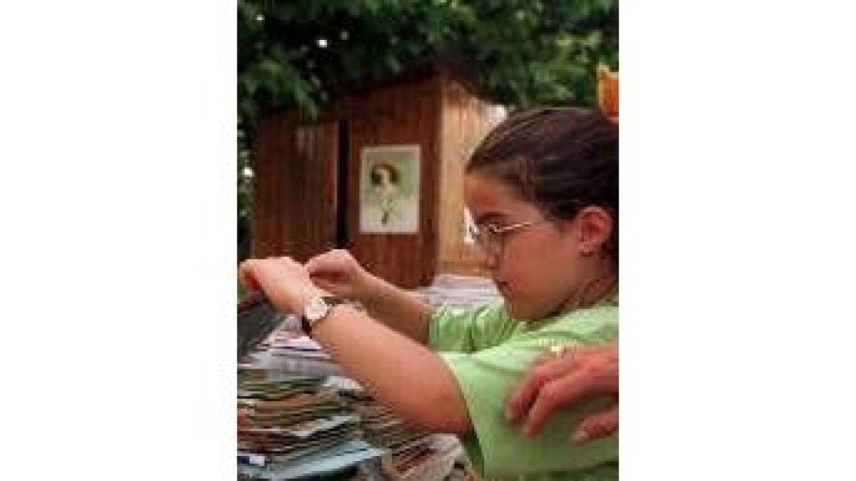 Una niña contempla material recuperado de los contenedores de papel