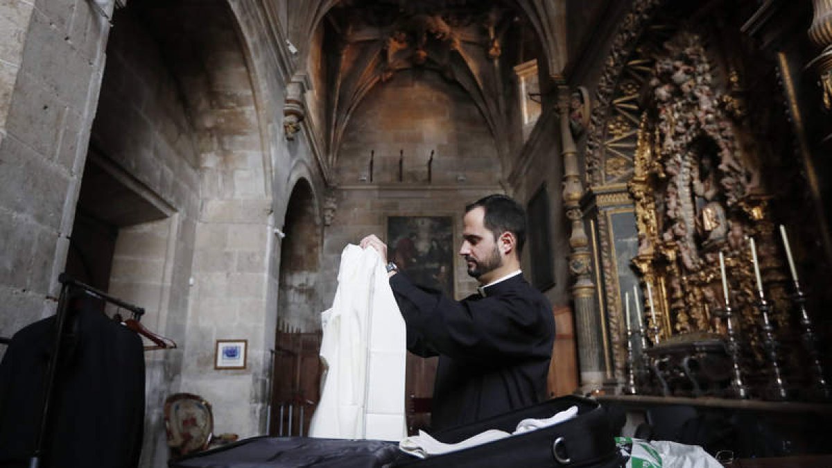 El sacerdote Guillermo Álvarez se coloca la casulla con la imagen de la Sagrada Familia sobre el alba. JESÚS F. SALVADORES