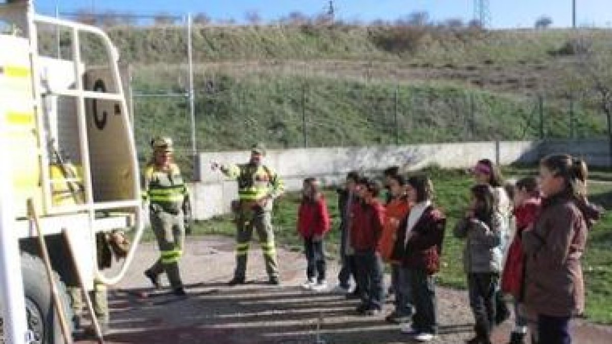 Un grupo de niños con agentes medioambientales junto al camión bomba contra incendios.