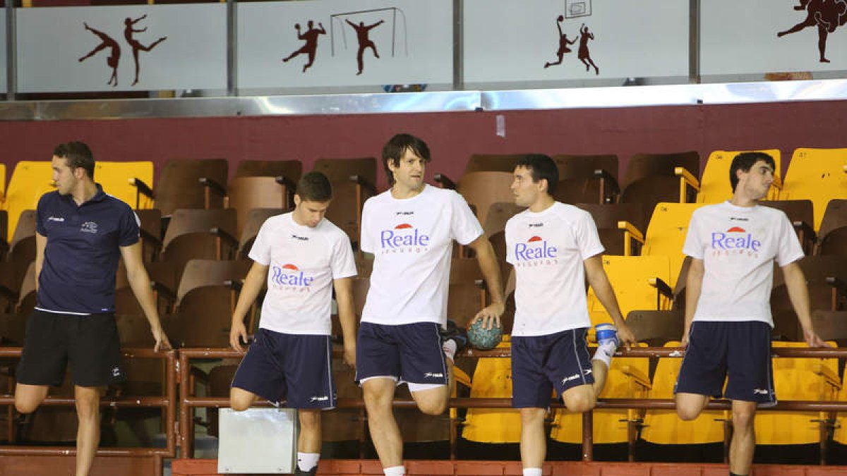 Los jugadores del Ademar realizan estiramientos en un entrenamiento en el Palacio.