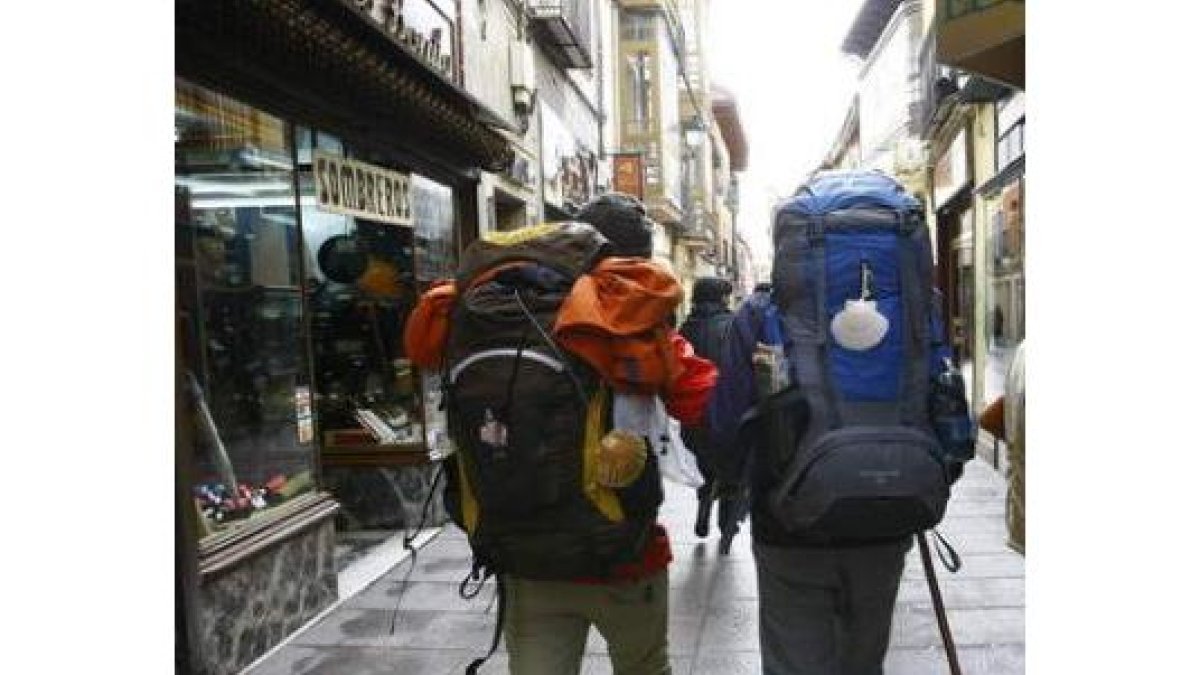 Dos peregrinos caminan por la calle de La Rúa en la capital.