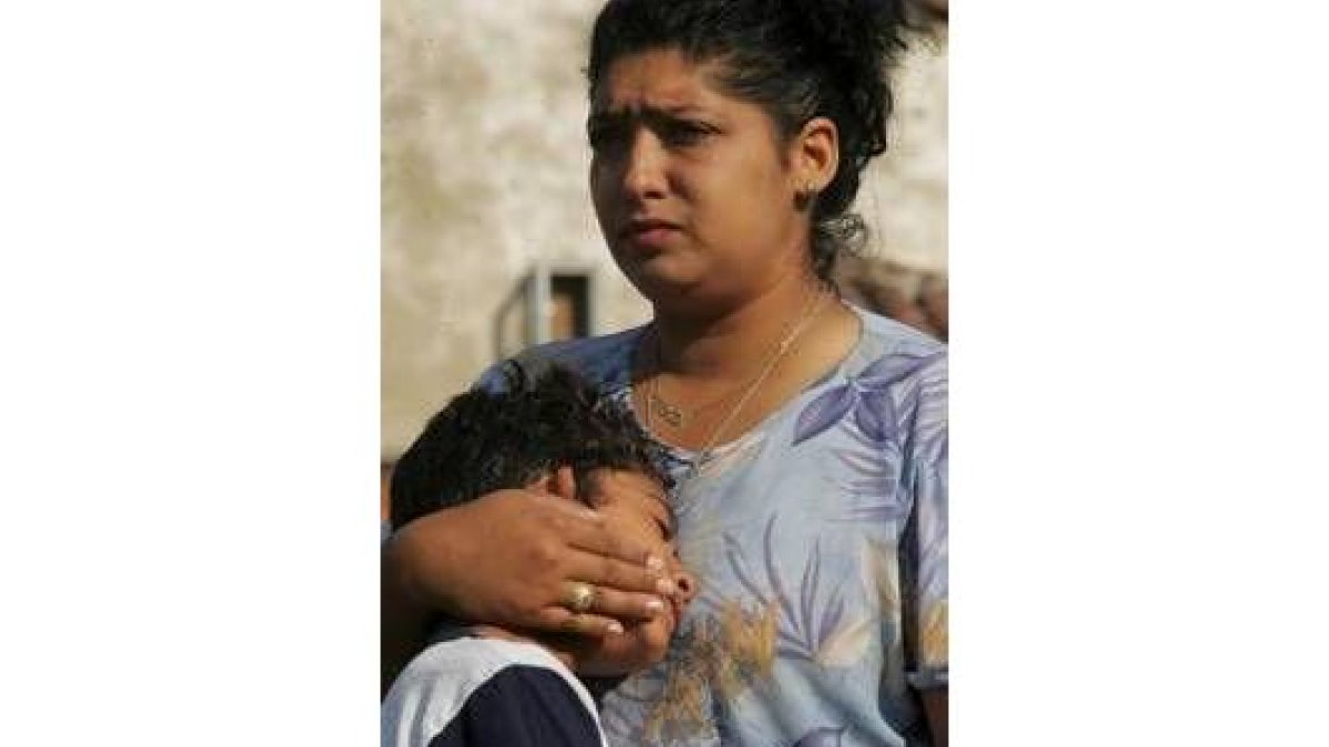 Una de las vecinas afectadas consuela a su hijo ante el desahucio