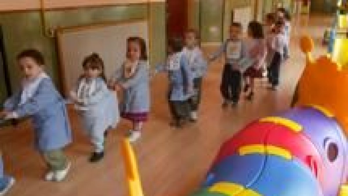 Varios niños juegan en la guardería a simular un tren, en una fotografía de archivo