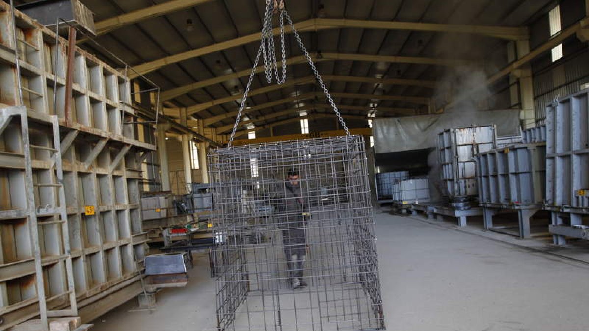 Uno de los trabajadores con una estructura transportada por una grúa.