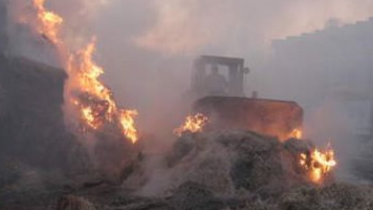 Una excavadora lucha contra las llamas en el incendio una granja de Palacios, en el 2008.