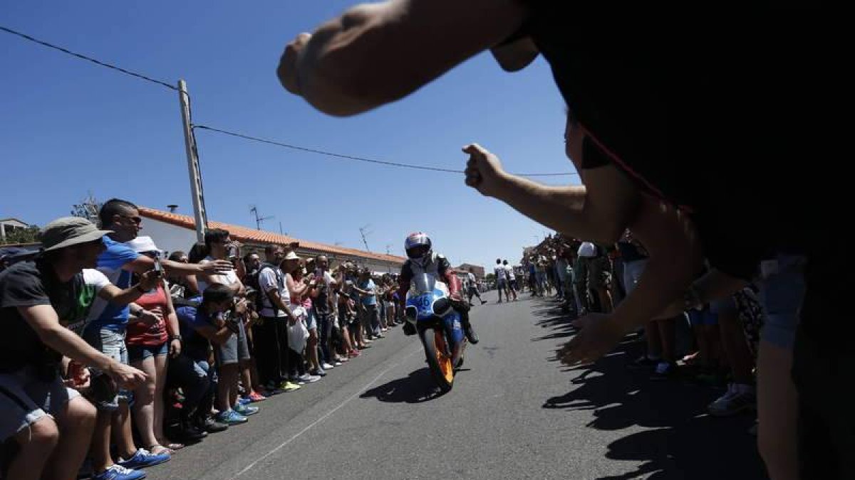 Los aficionados hacen un pasillo de honor en la recta de meta al vencedor en la categoría reina del Gran Premio de La Bañeza, el piloto murciano Ángel Jesús Castillejo.