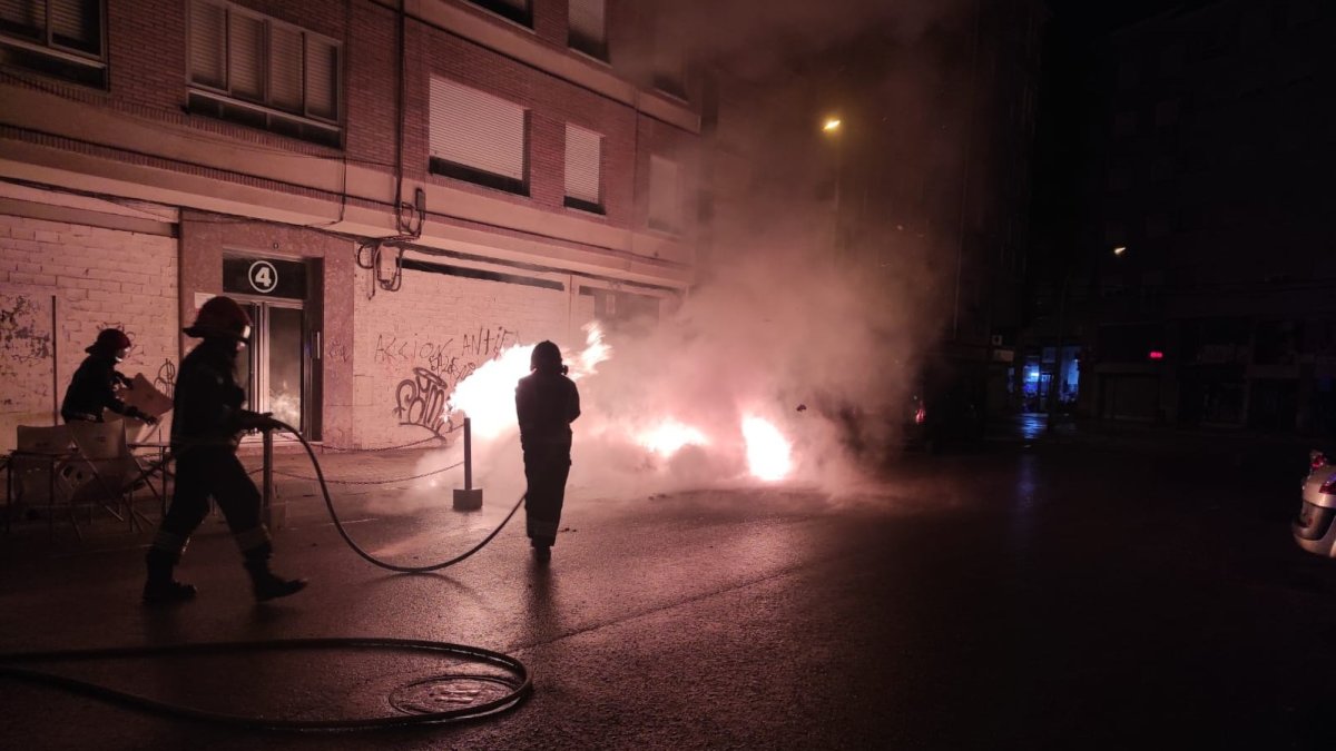 Los bomberos, en la madrugada del pasado martes, sofocando el incendio en un contenedor. DL