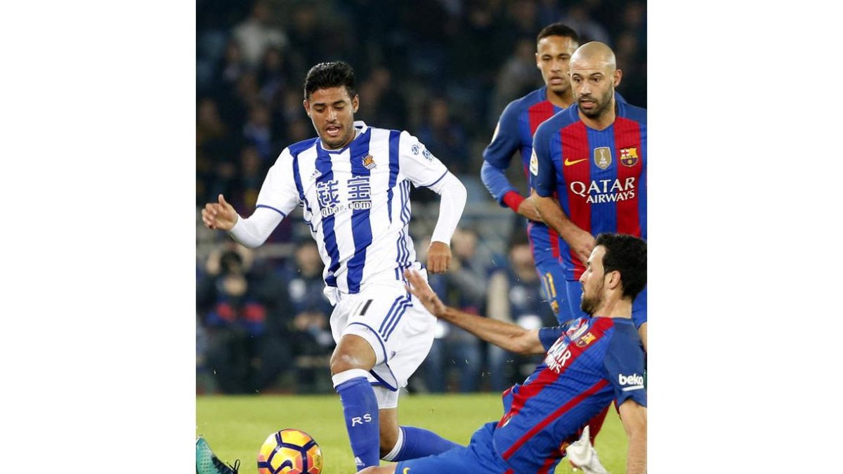 Vela intenta zafarse de Busquets durante el partido entre la Real y el Barcelona. JUAN HERRERO