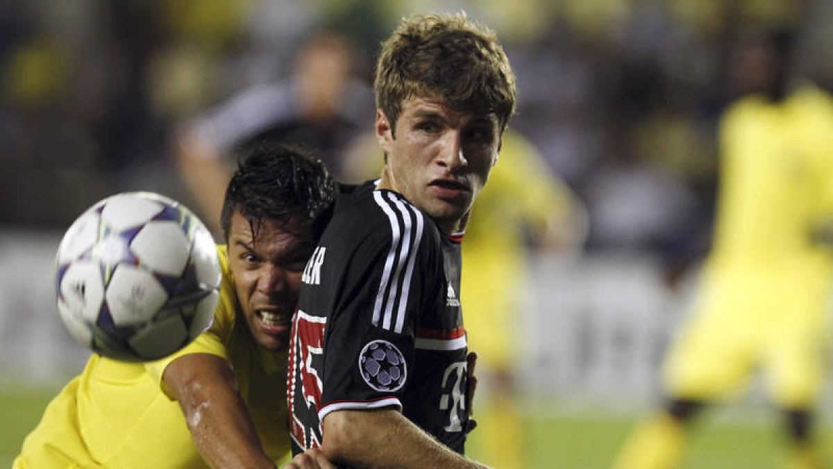 El defensa del Villarreal, José Catalá, disputa el balón con el centrocampista Thomas Müller.