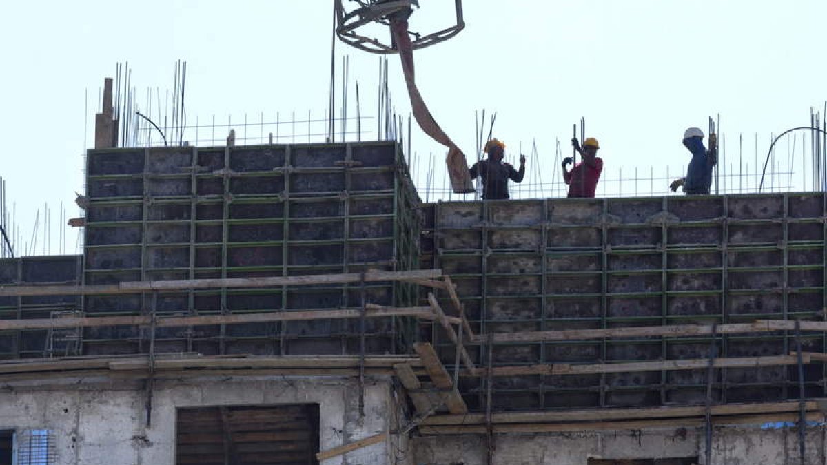 Operarios palestinos trabajan en las nuevas viviendas.