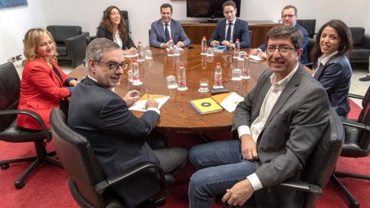 Los equipos negociadores de Partido Popular y Ciudadanos encabezados por Juanma Moreno c y Juan Marin 2d al comienzo de la segunda reunion que mantuvieron el pasado martes en el Parlamento andaluz.