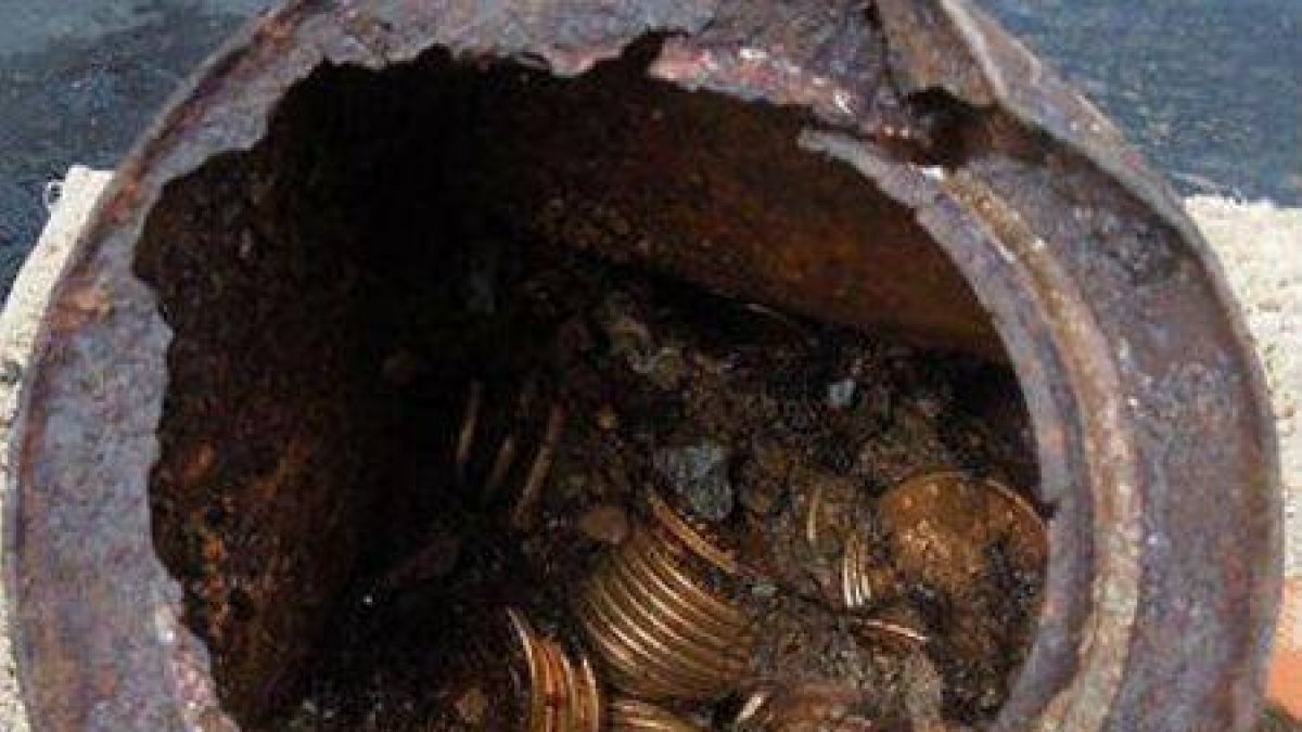 Una de las ocho latas oxidadas donde se halló el tesoro.