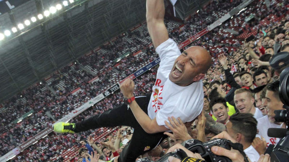 Los futbolistas del Sporting mantean a su técnico, el ‘Pitu’ Abelardo, después de lograr la permanencia en El Molinón. ALBERTO MORANTE