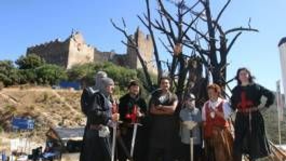 Templarios en el monumento contra el fuego con troncos quemados, frente al castillo de Cornatel