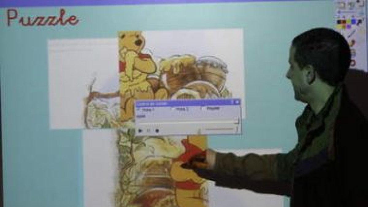Un profesor da una clase apoyado por una pizarra digital.