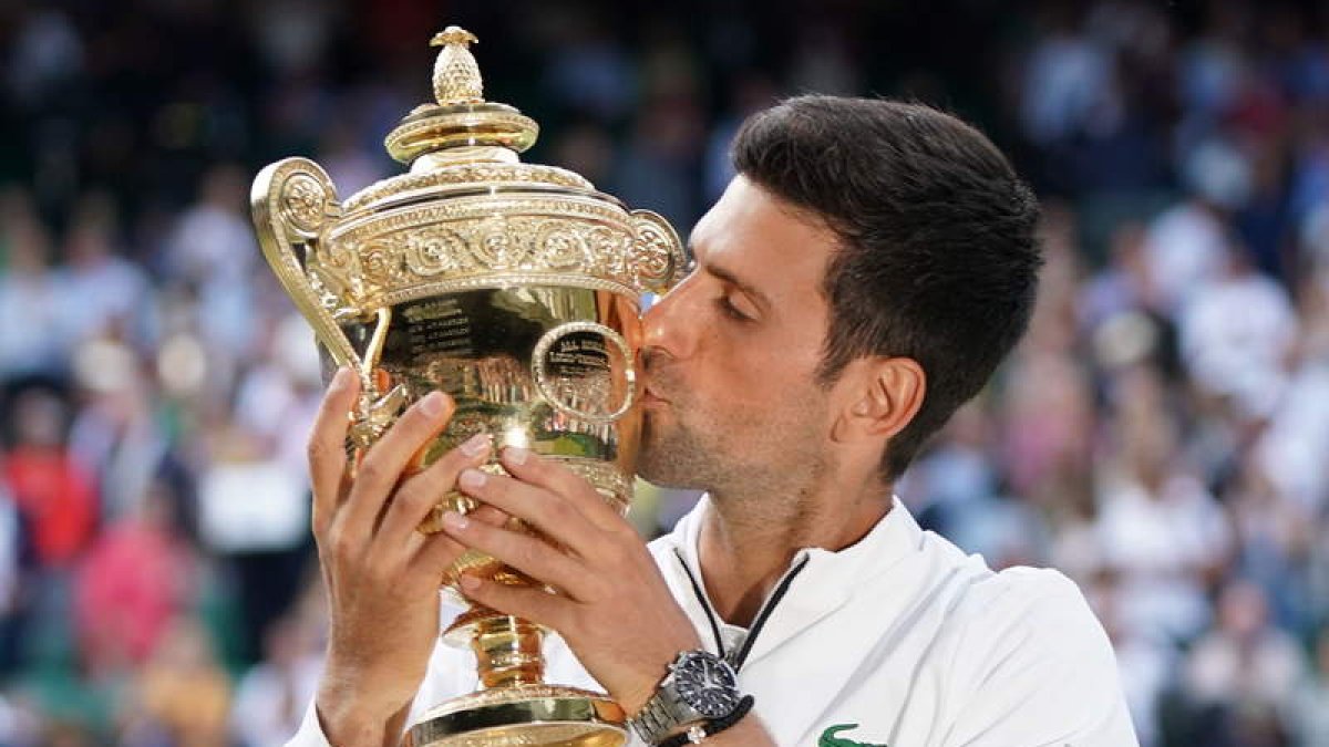 Novak Djokovic besa la copa de campeones tras ganar a Roger Federer en la final más larga de la historia en Wimbledon. NIC BOTHMA