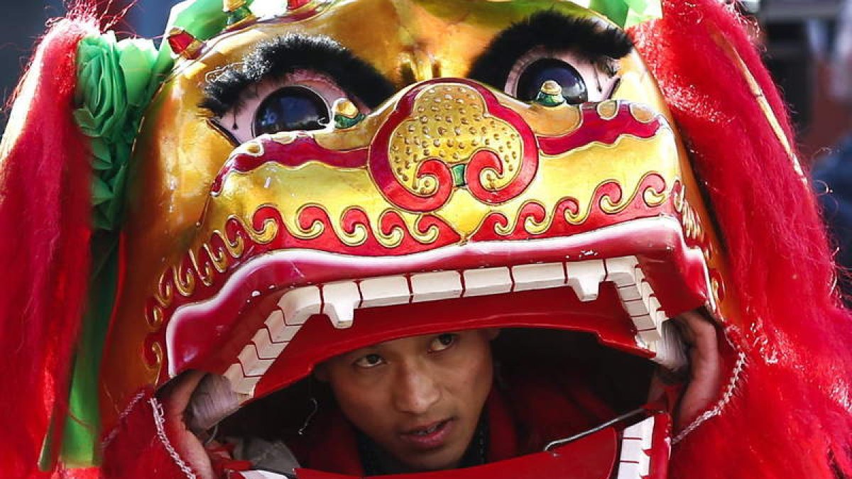 Un artista actúa durante la presentación de la danza del león, en Pekín