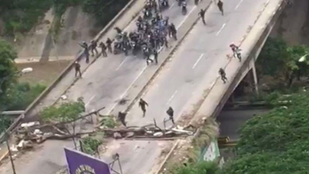 La policía venezolana irrumpe, en motos, para dispersar una manifestación.