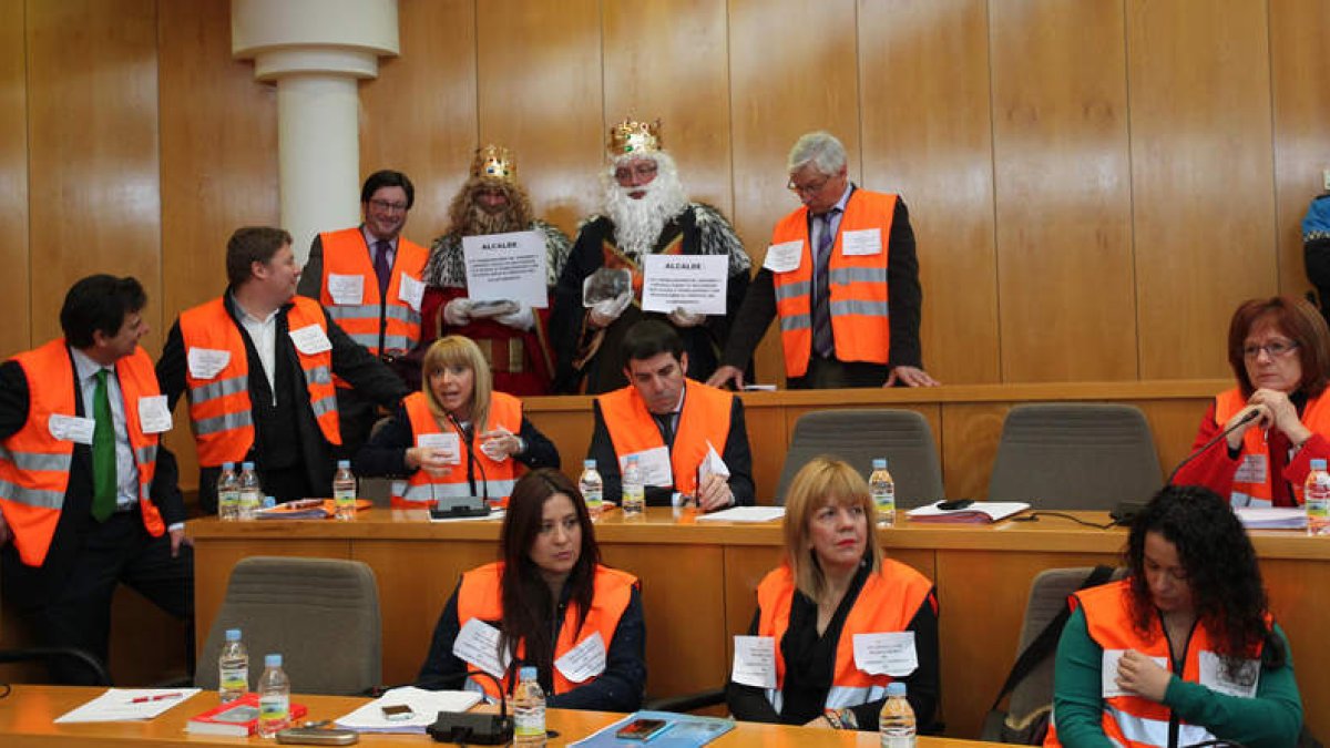 La oposición ataviada con chalecos naranjas rodeada de dos reyes magos, ayer.