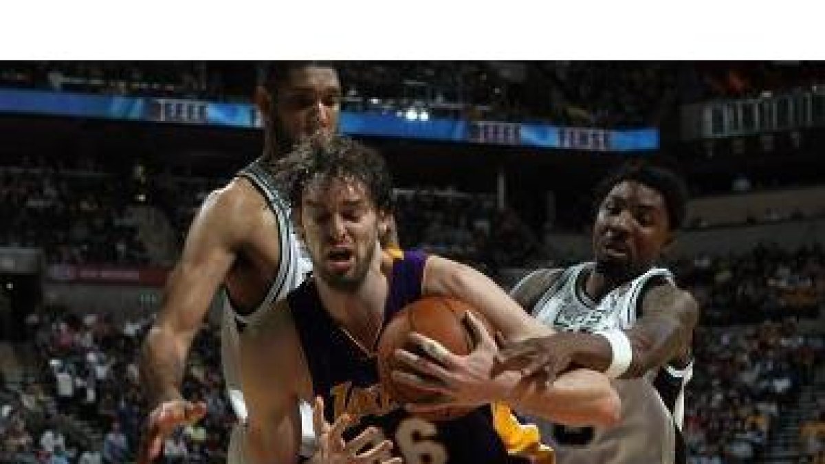Gasol disputa el balón con dos contrarios.