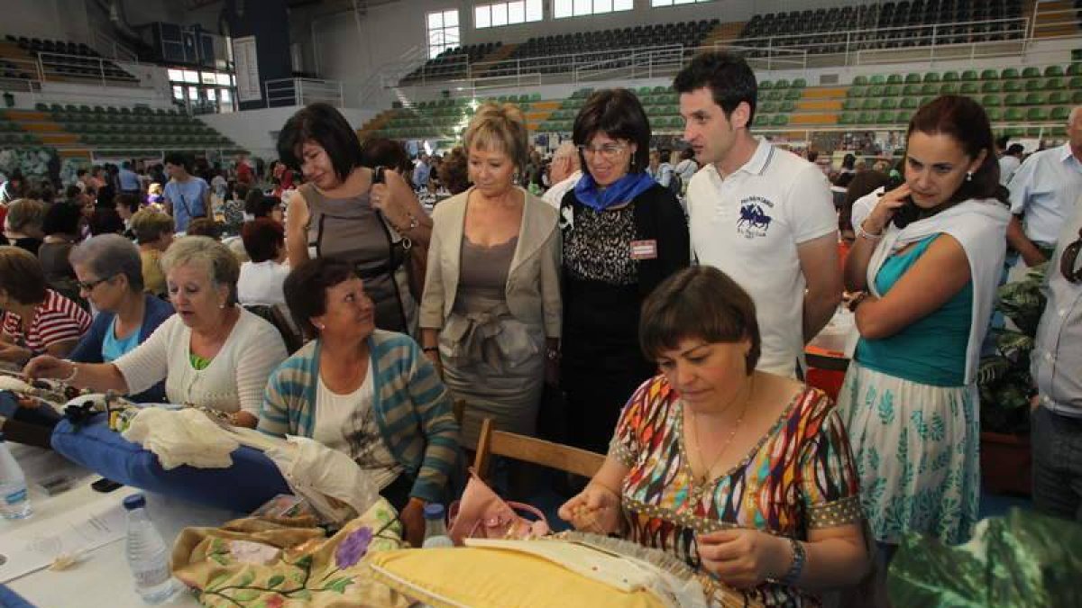 Mari Crespo y Susana Saiz admirando las labores de las artesanas de la muestra.