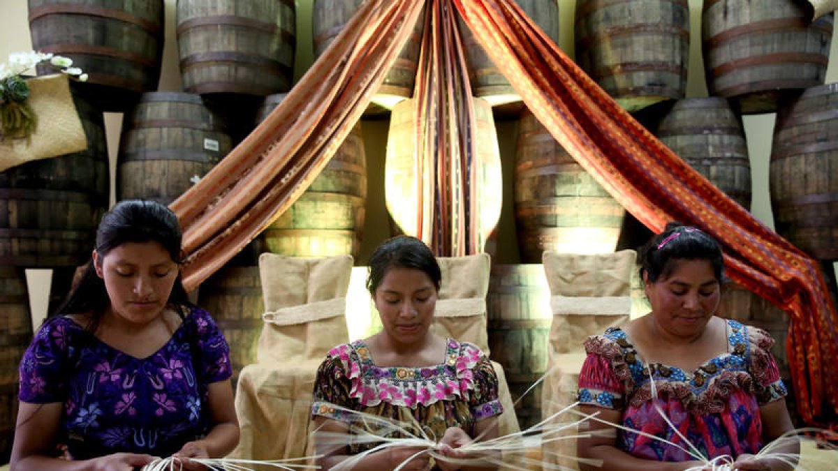 Mujeres tejen los detalles de una botella de ron ‘Zacapa’, en el altiplano de Quetzaltenango (Guatemala)